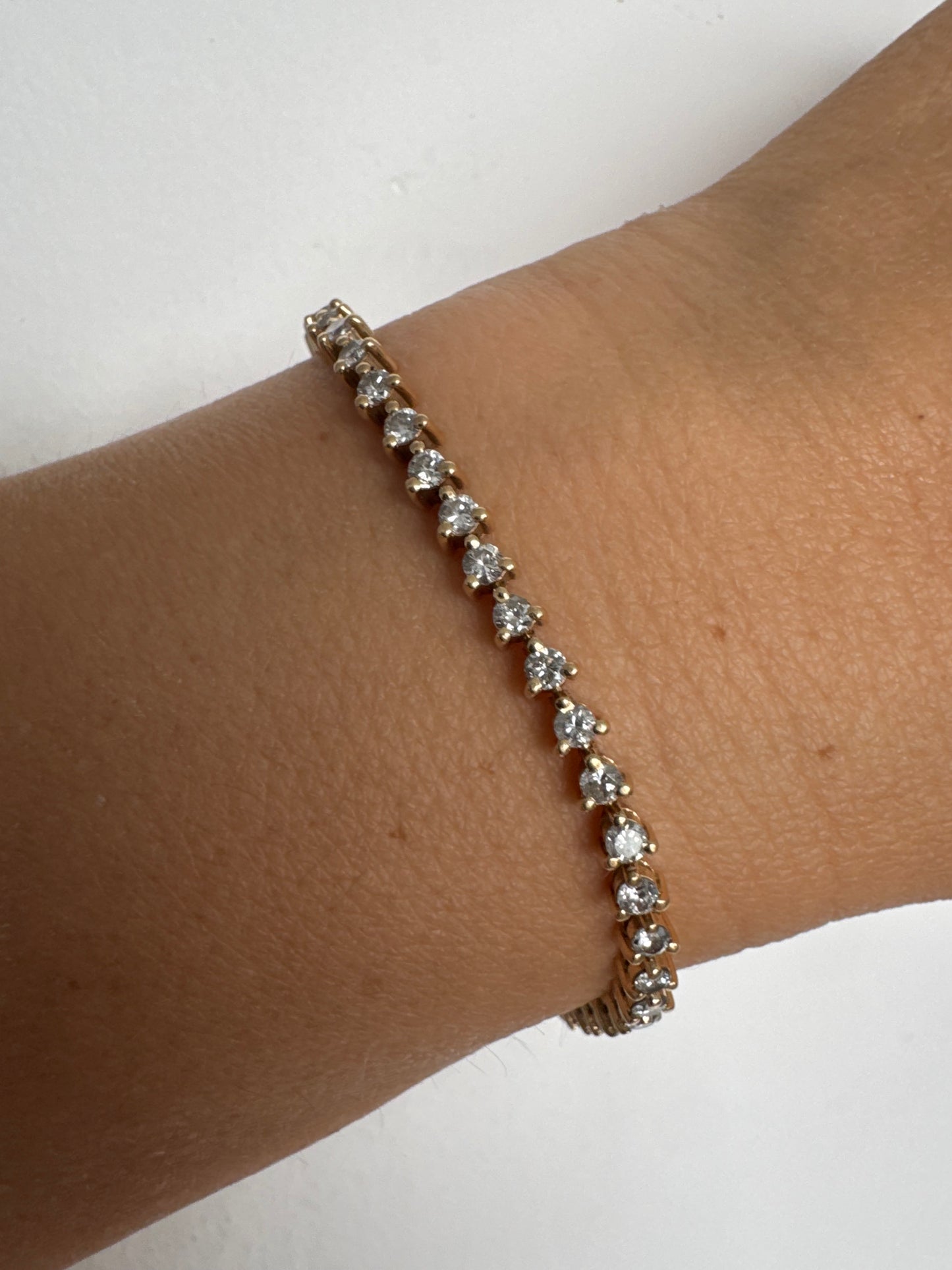 צמיד טניס קלאסי מזהב 14 קראט, משובץ שורה רציפה של יהלומים עגולים המעניקים ברק עדין ואלגנטי.