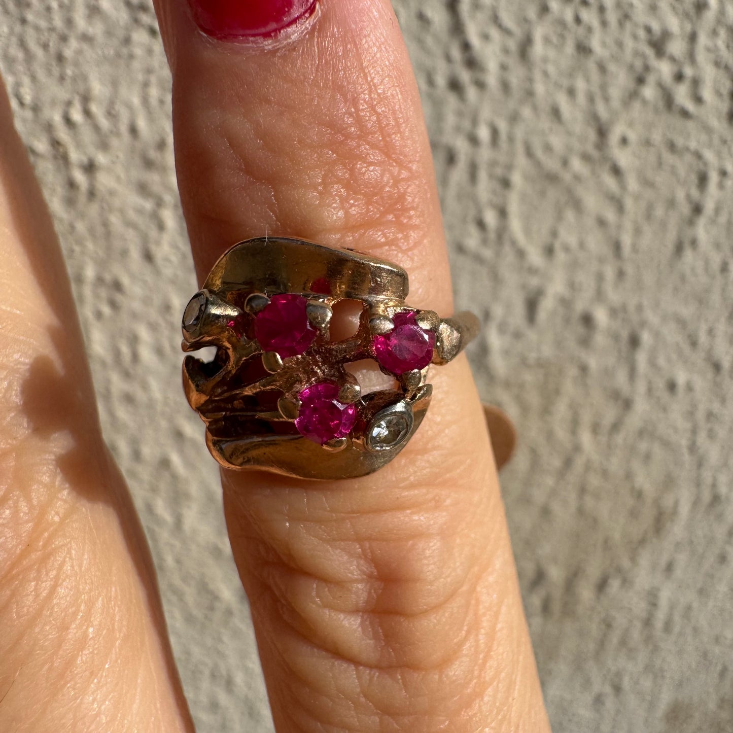 טבעת זהב צהוב 14 קראט, משובצת אבני רובי ושני יהלומים להדגשה, בעיצוב פיסולי ומלא אופי.