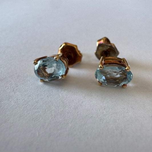 18K gold stud earrings set with oval-cut Aquamarines.