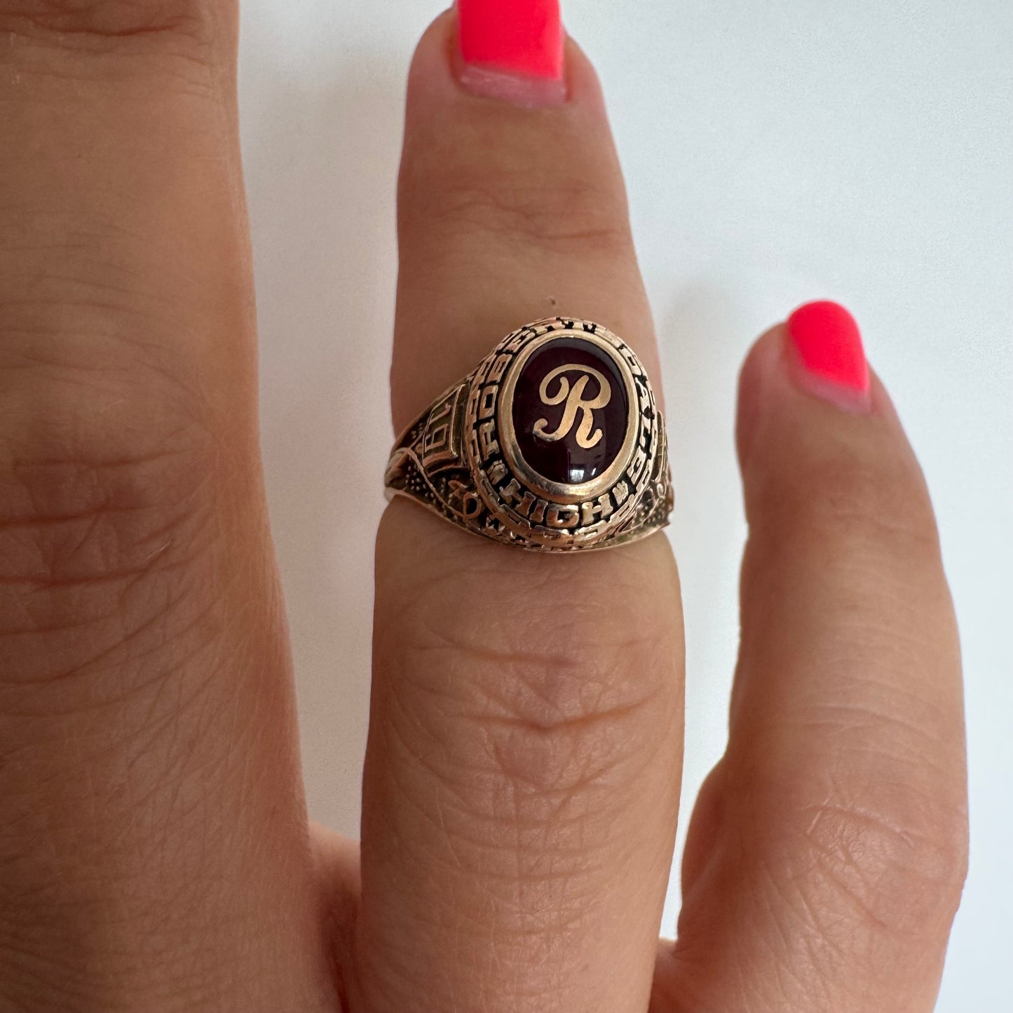 טבעת מחזור (Class Ring) מזהב 10 קראט, בעלת עיצוב אמריקאי קלאסי ובמרכזה אבן אדומה עם האות R עם חריטות וסמלים המעניקים לה אופי ייחודי ונוסטלגי.