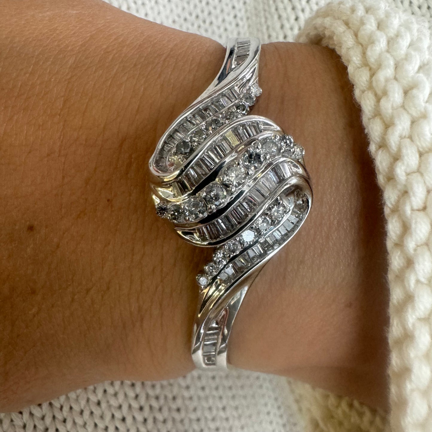 צמיד מרהיב מזהב לבן 14 קראט, בעיצוב גלים דינמי המשובץ בשיבוץ מרוכב של יהלומים עגולים ובחיתוך באגט.