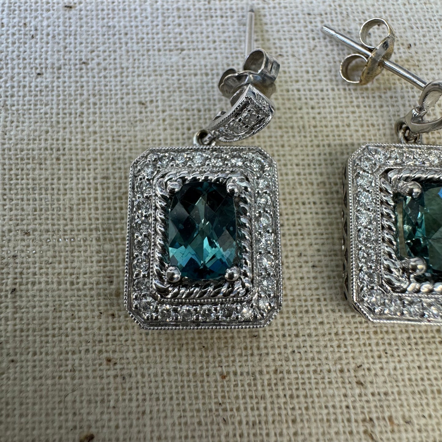 14K gold drop earrings set with emerald-cut Blue Topaz, surrounded by a halo of sparkling Diamonds