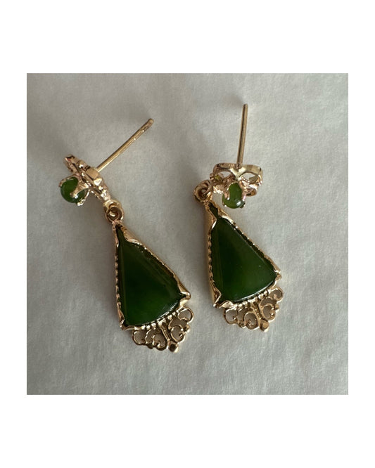 עגילי זהב צהוב 14 קראט משובצים אבני ג׳ייד ירוקות בגוון עמוק בחיתוך משולש.