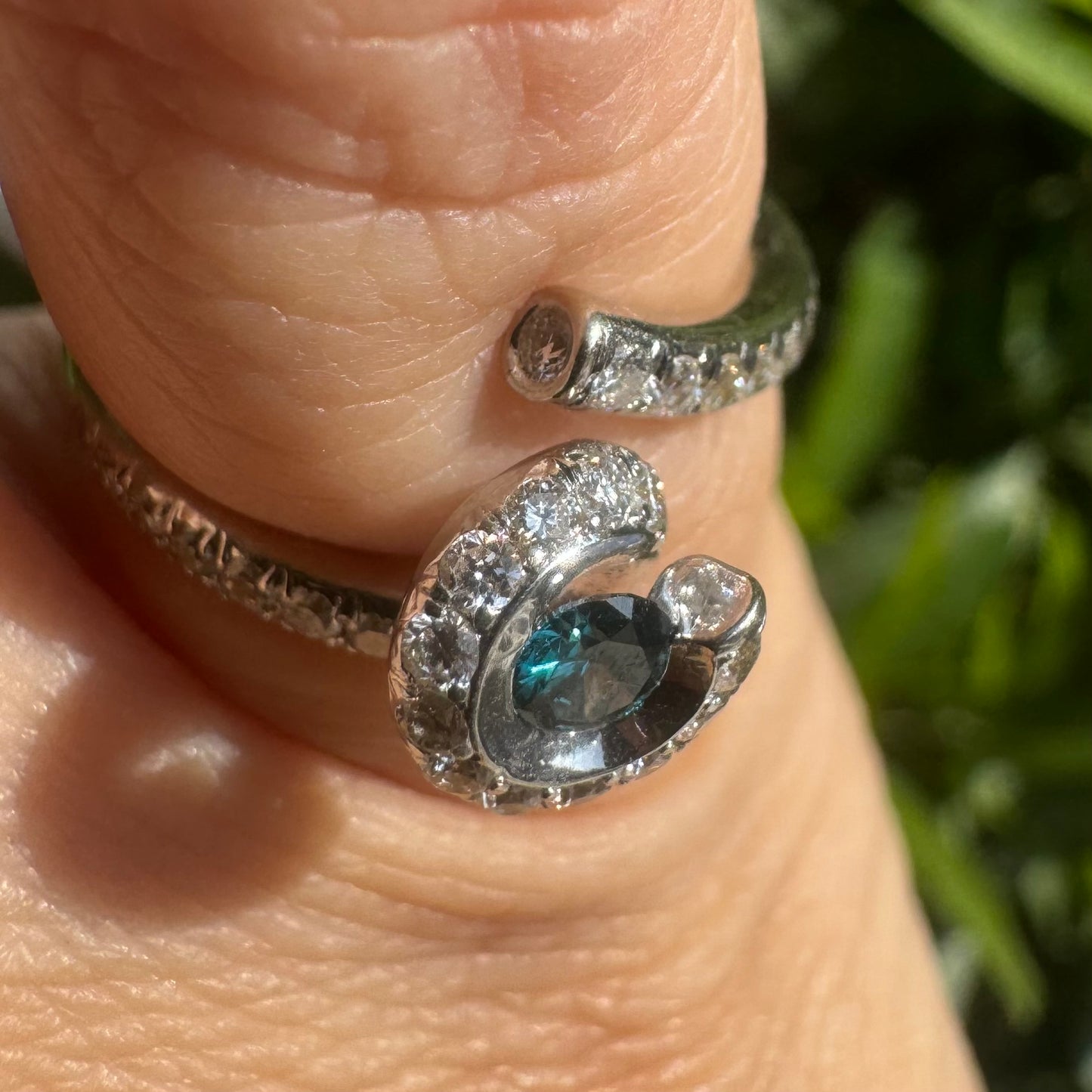 18K gold ring set with a vivid blue Diamond at its heart, embraced by a shimmering halo of white diamonds and a bold open design