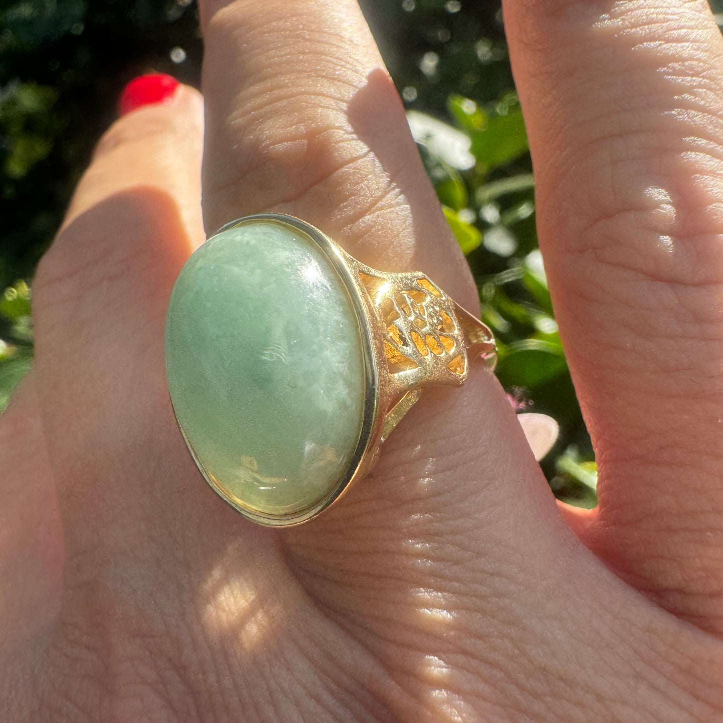 14K gold ring featuring a large oval light green Jade with a smooth polished finish, set in a classic bezel setting.