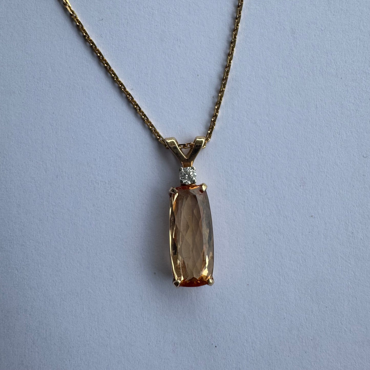 שרשרת זהב 14 קראט עם תליון זהב 14 קראט משובץ אבן קוורץ מלבנית בגוון שמפניה חמים, ומעליה יהלום נוצץ להדגשה עדינה של הברק.