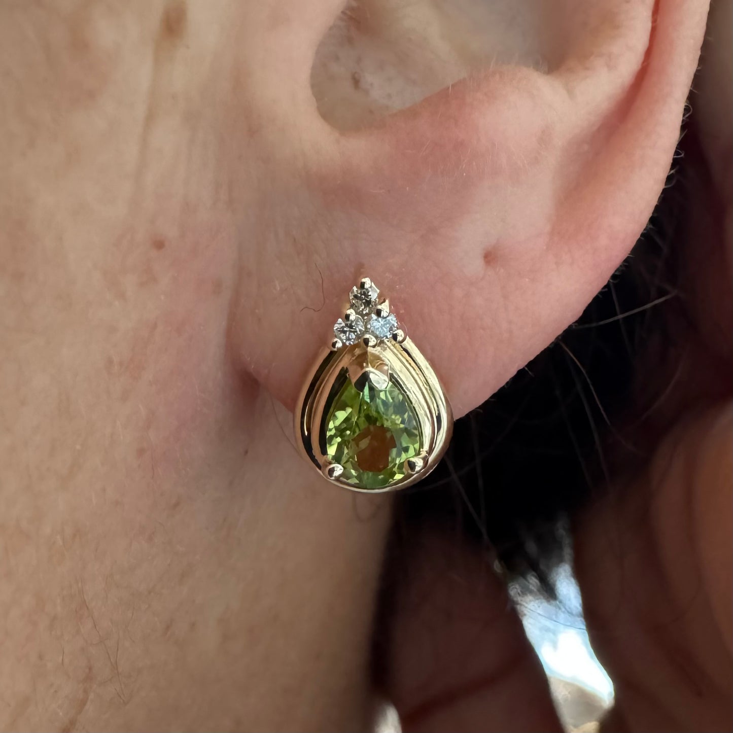 עגילי זהב צהוב 14 קראט משובצים אבני פרידוט בחיתוך טיפה, בגוון ירוק רענן ובוהק. 