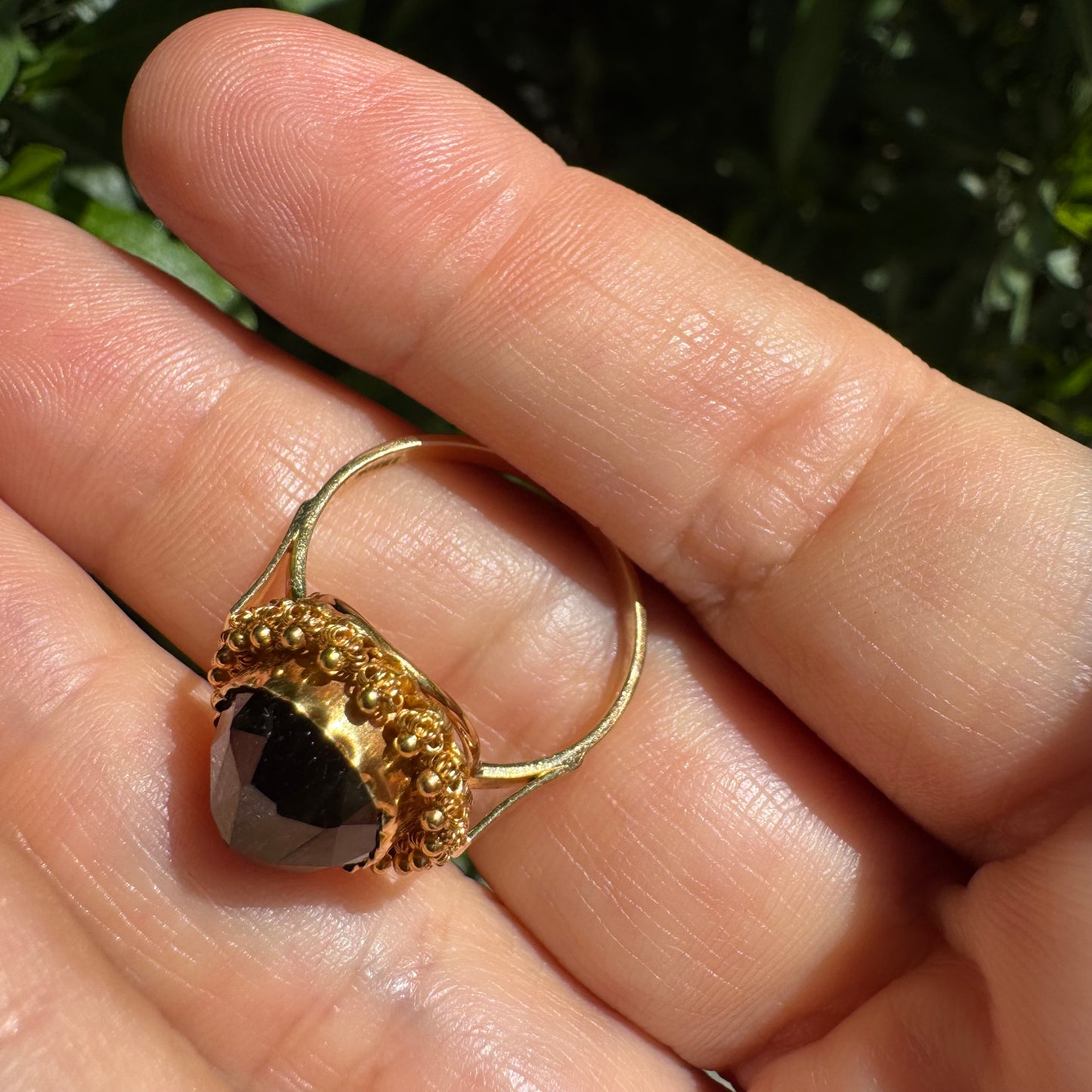 14K gold ring set with a large Garnet surrounded by delicate gold details