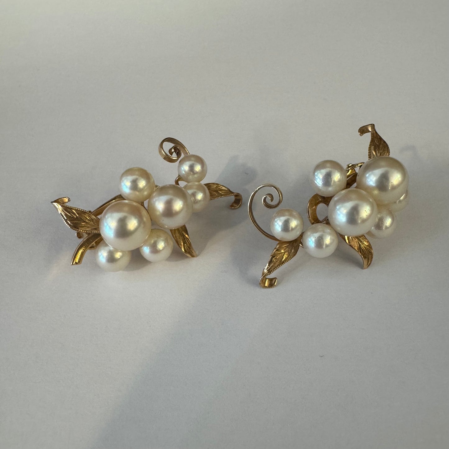 עגילי קליפס זהב 14 קראט, משובצים אשכול פנינים בגווני לבן-קרם.