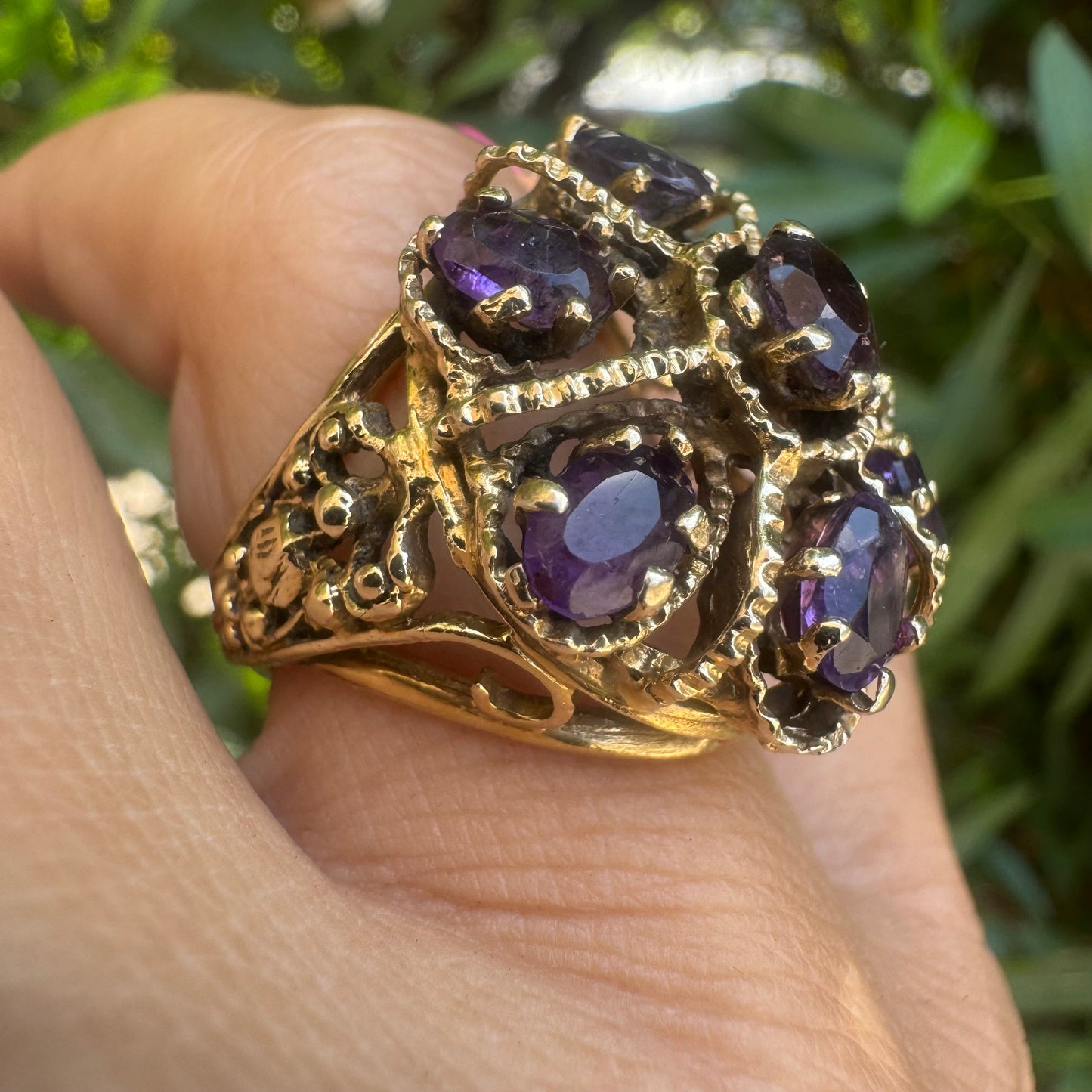 14K gold ring set with deep purple amethysts in an ornate floral design.