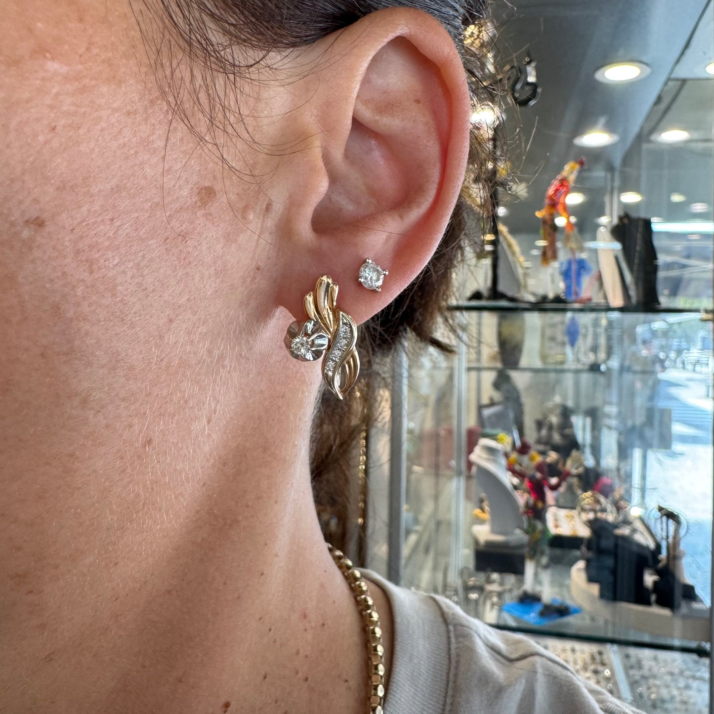 עגילי זהב 14 קראט בעיצוב מתעגל ואלגנטי המשובצים יהלומים נוצצים .