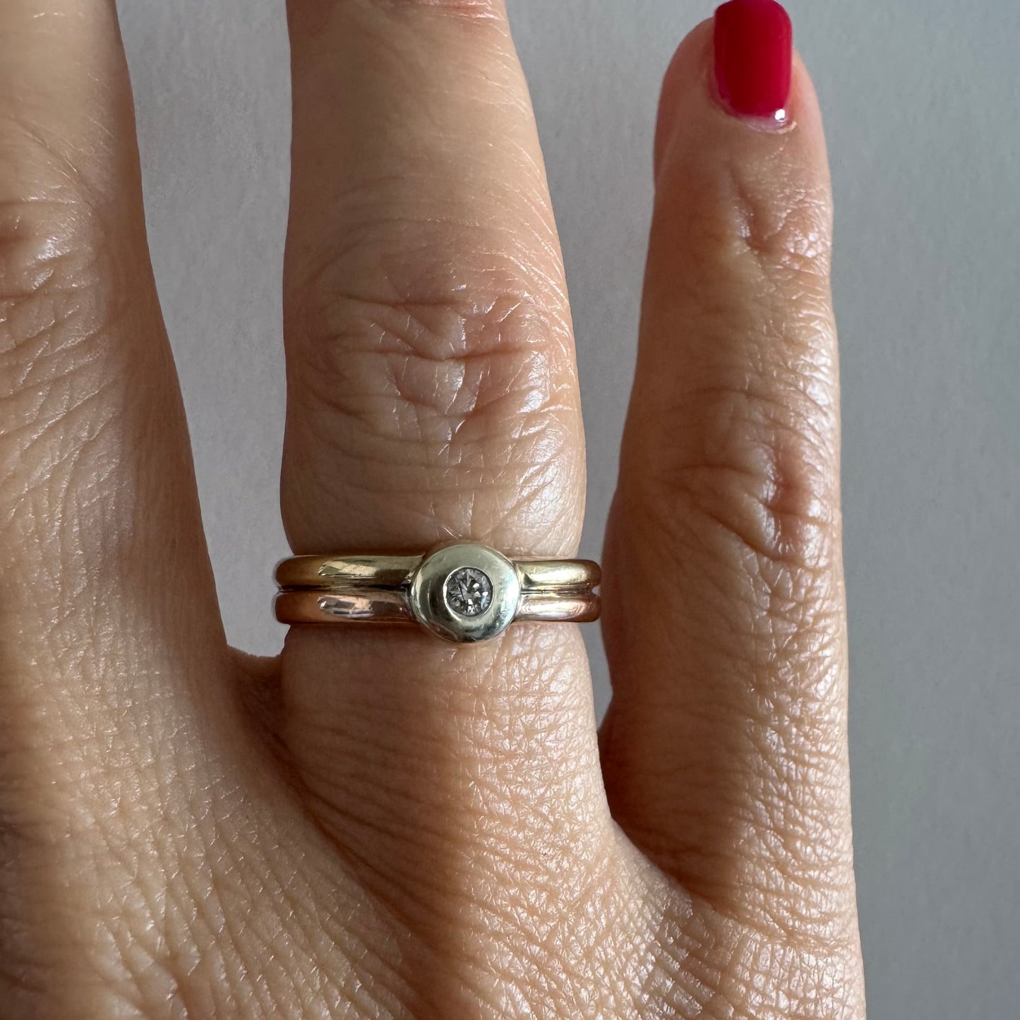 טבעת זהב 10 קראט בעיצוב מינימליסטי ונקי, משובצת יהלום מרכזי במסגרת חלקה (Bezel).