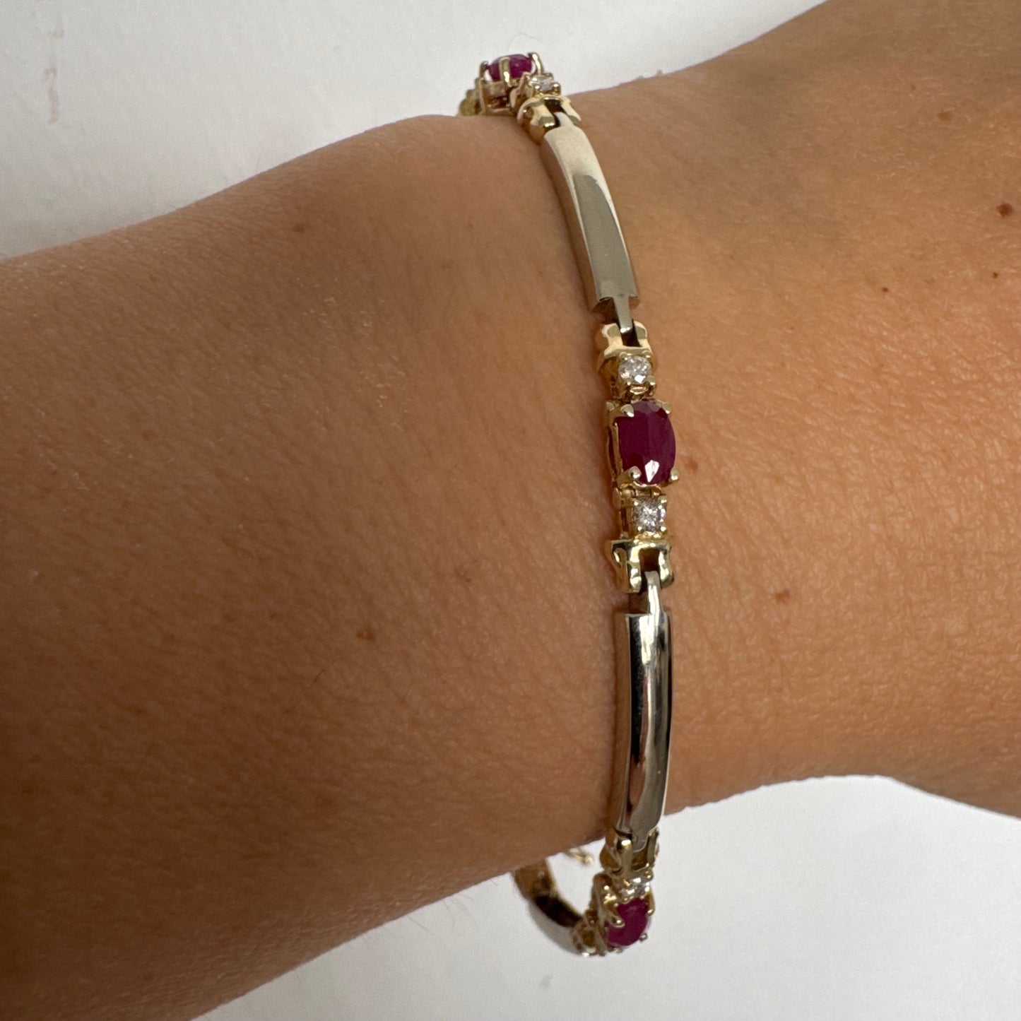צמיד זהב צהוב 14 קראט משובץ אבני רובי אדומות בחיתוך אובלי, עם יהלומים המשובצים ביניהן להוספת ברק עדין.