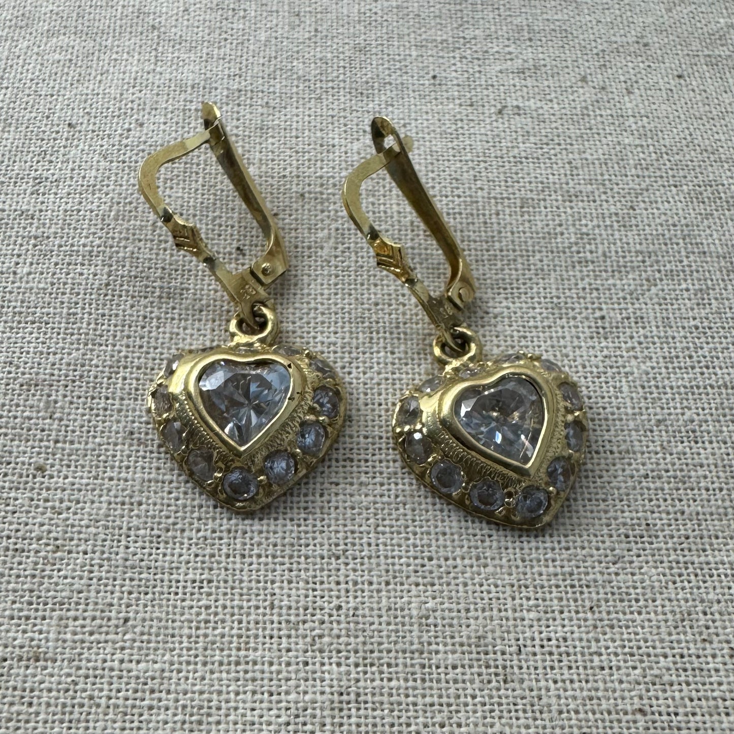 14K gold drop earrings set with a heart-cut central stone & surrounded by a halo of delicate gems.