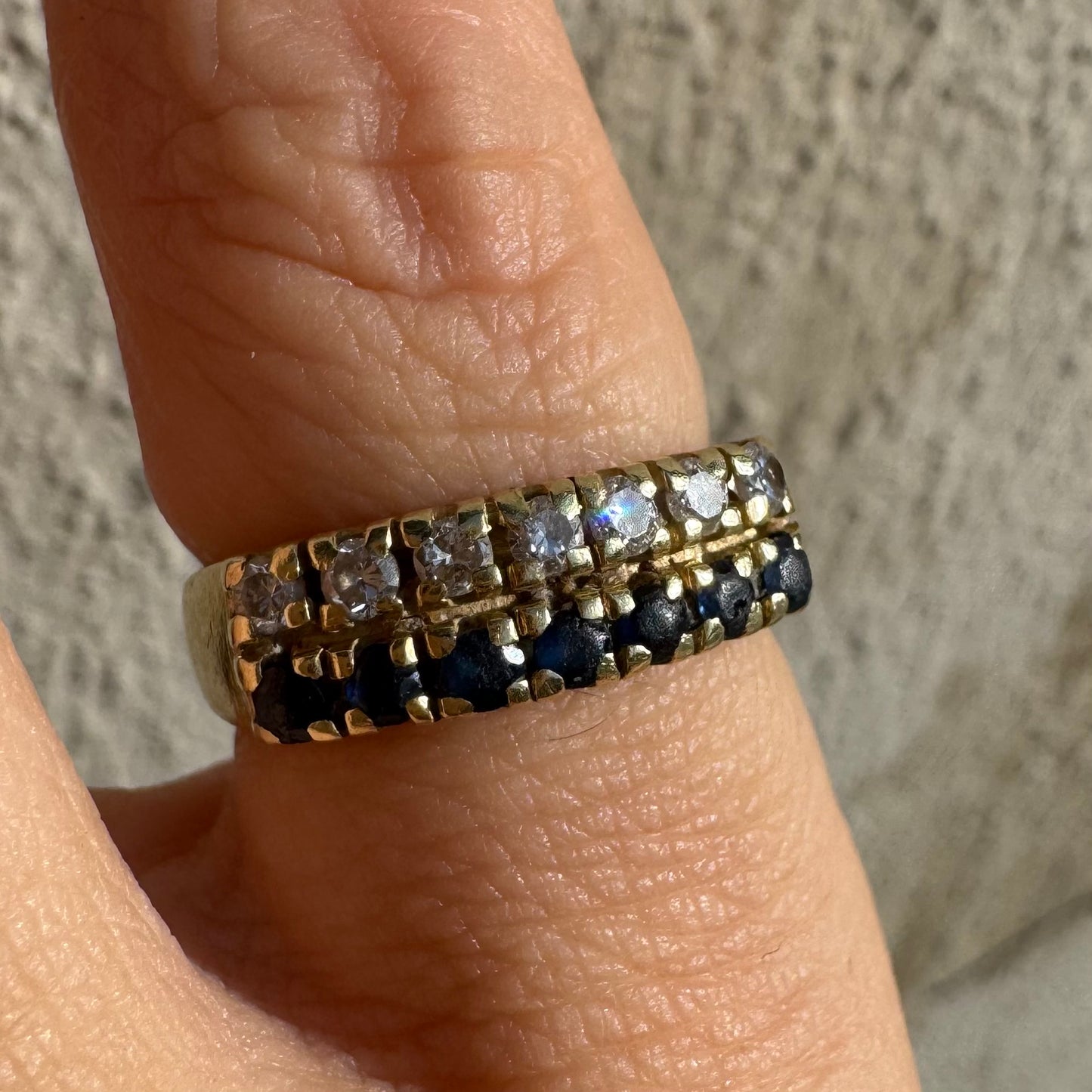 טבעת זהב צהוב 14 קראט, עם שורה של יהלומים נוצצים ושורה נוספת של ספירים כחולים.