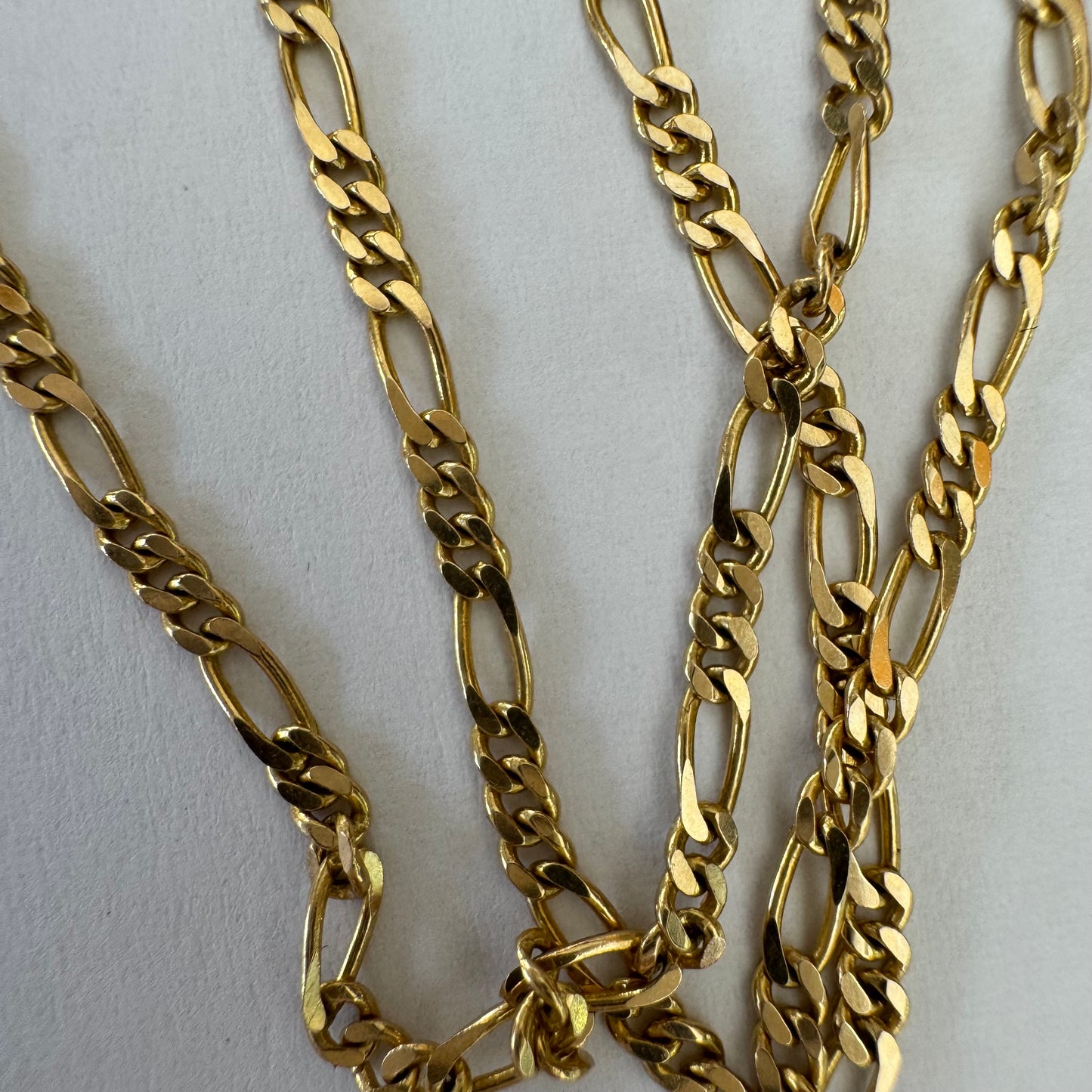 שרשרת זהב צהוב 14 קראט בעיצוב חוליות דקות ומוארכות עם טוויסט עדין שנותן לה מראה אלגנטי ונקי.