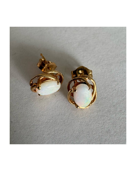 עגילי זהב צהוב 14 קראט משובצים אבני אופל אובליות בגוון לבן חלבי עם משחקי צבע טבעיים ועדינים.