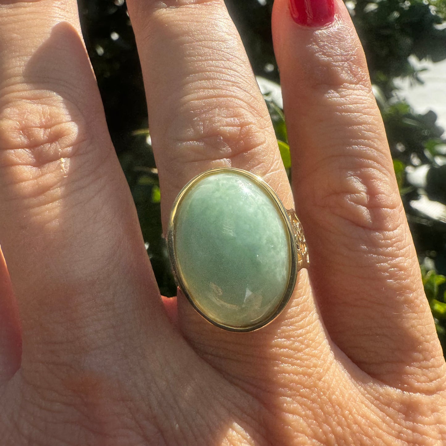 14K gold ring featuring a large oval light green Jade with a smooth polished finish, set in a classic bezel setting.