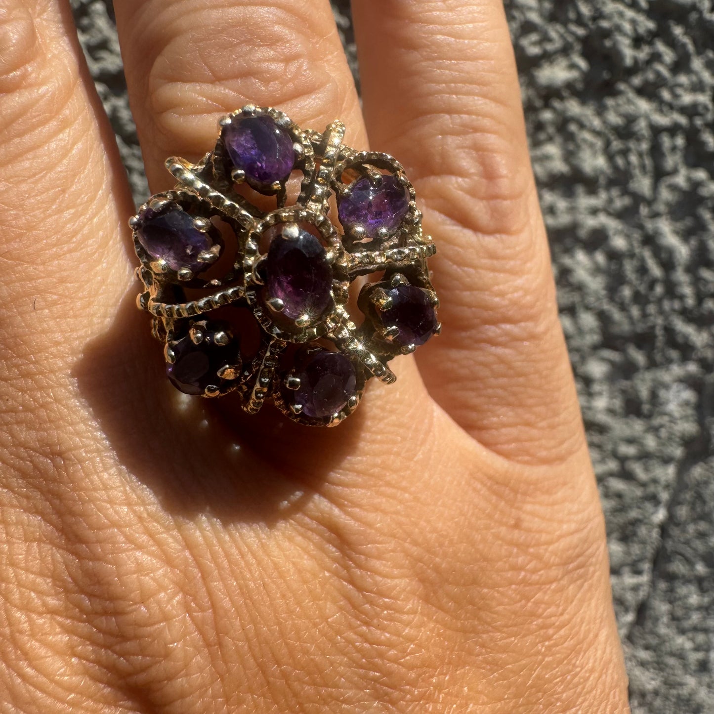 14K gold ring set with deep purple amethysts in an ornate floral design.