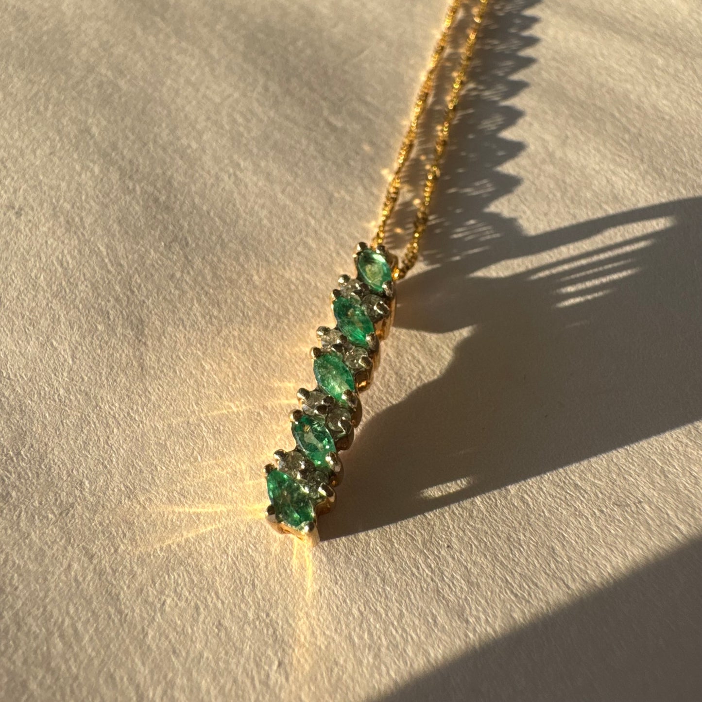 תליון זהב 14 קראט משובץ אמרלדים בחיתוך מרקיזה ויהלומים נוצצים. 