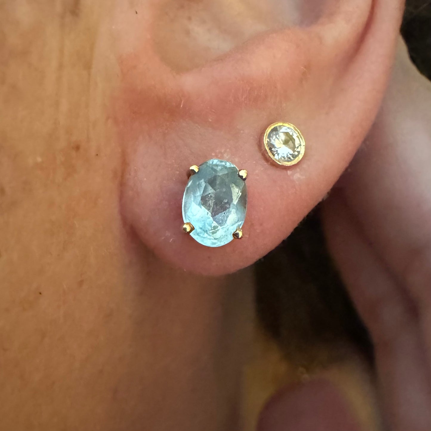 18K gold stud earrings set with oval-cut Aquamarines.