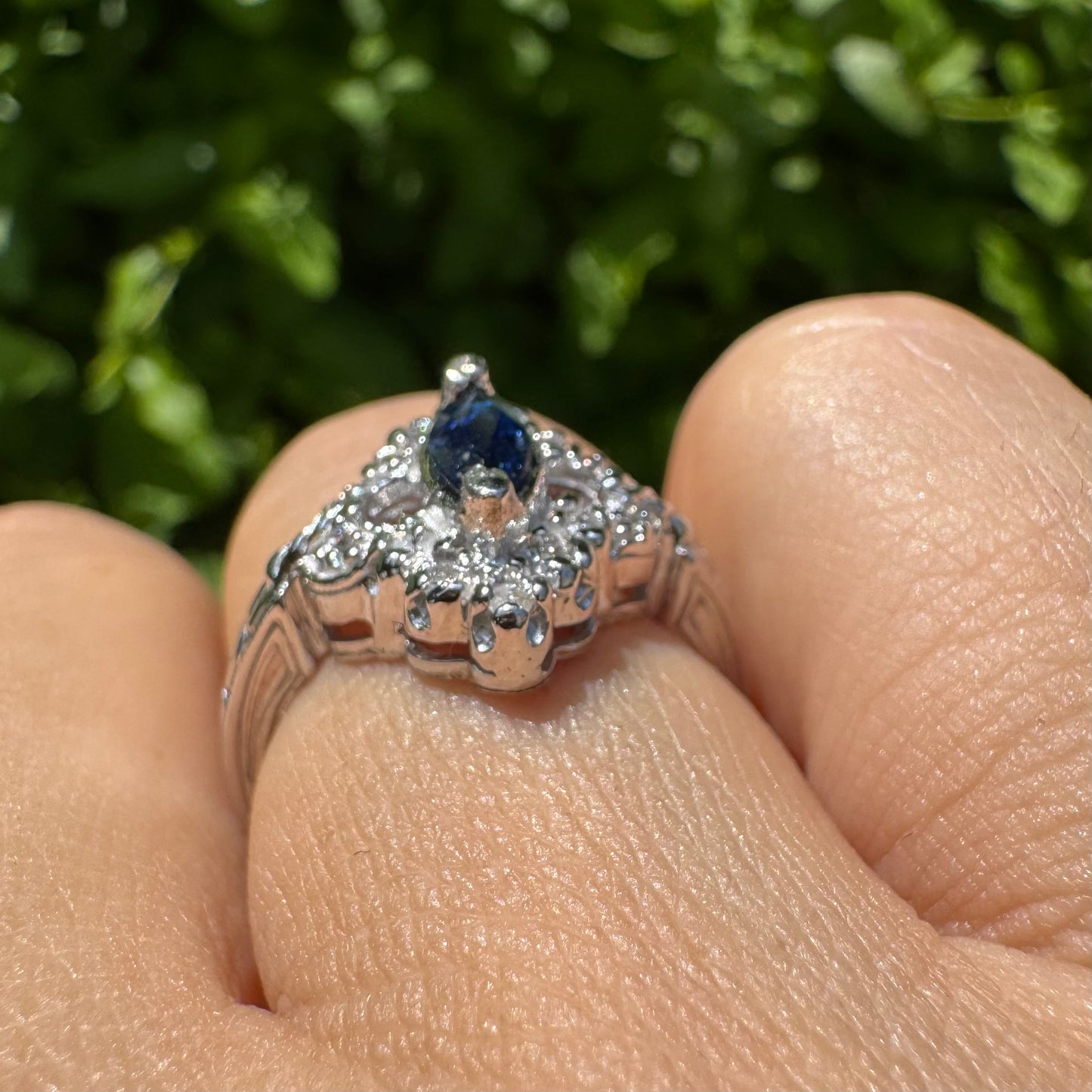 14K gold ring set with a marquise-cut Sapphire at its center, framed by an intricate halo of sparkling Diamonds