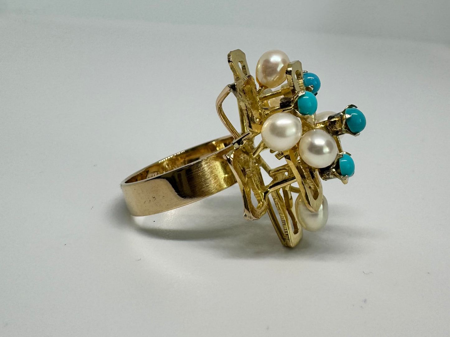 14K gold ring with a textured design, set with round white pearls and turquoise stones for a striking contrast.