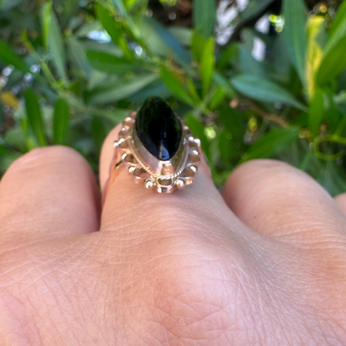 14K gold ring featuring a long marquise-shaped black Onyx stone, framed with delicate decorative details around the setting.