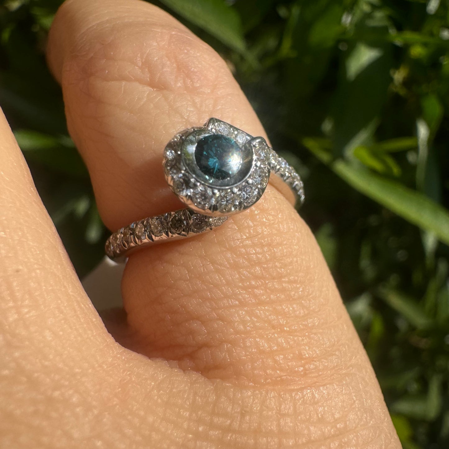 18K gold ring set with a vivid blue Diamond at its heart, embraced by a shimmering halo of white diamonds and a bold open design