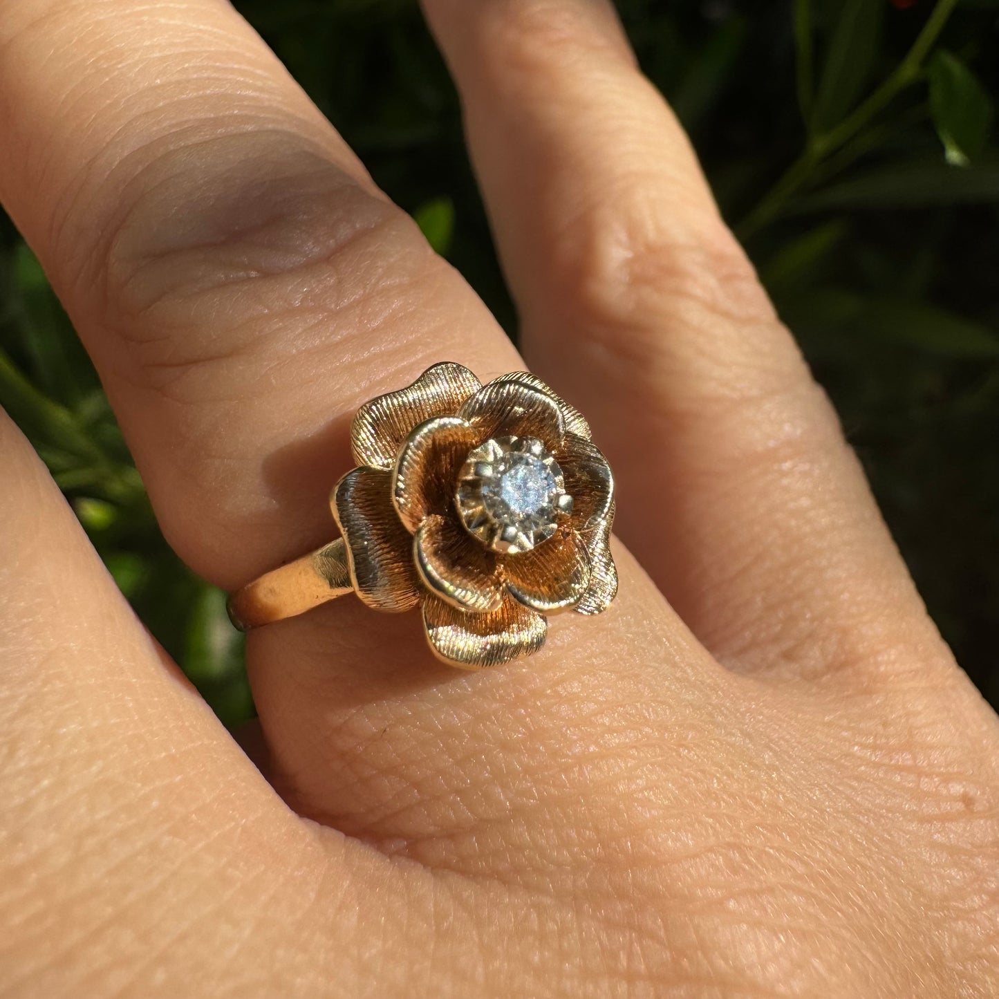 14K Gold floral ring set with delicately textured petals and a sparkling Diamond at the center