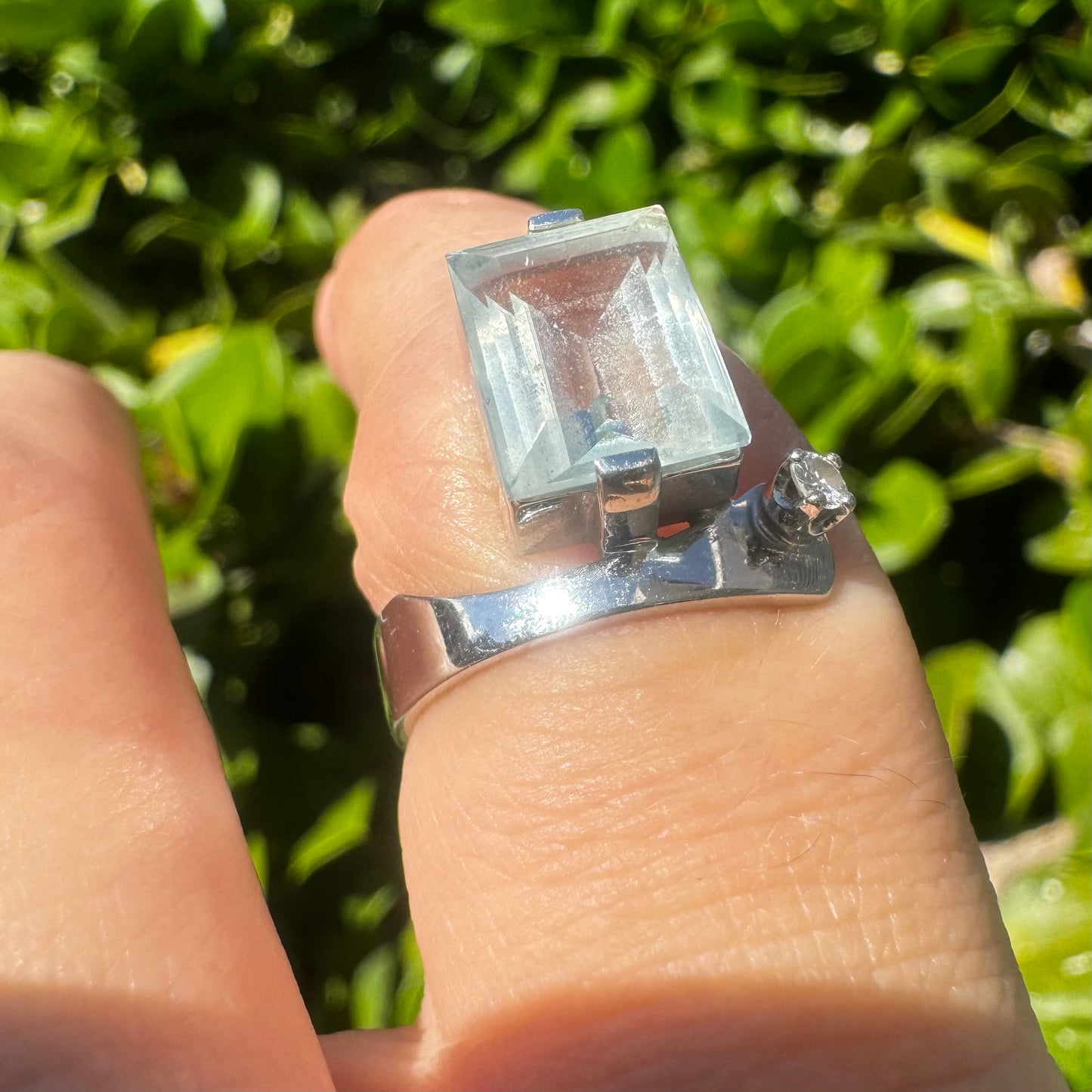 18K gold ring set with a rectangular step-cut Aquamarine set in a sculptural white gold band & a sparkling Diamond