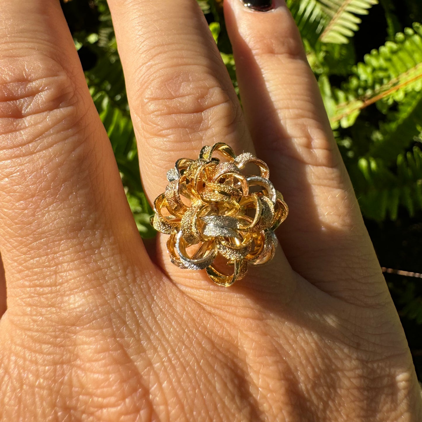 18K gold ring set with intricately textured loops in yellow, white, and rose gold, forming a bold floral-inspired sculptural design.