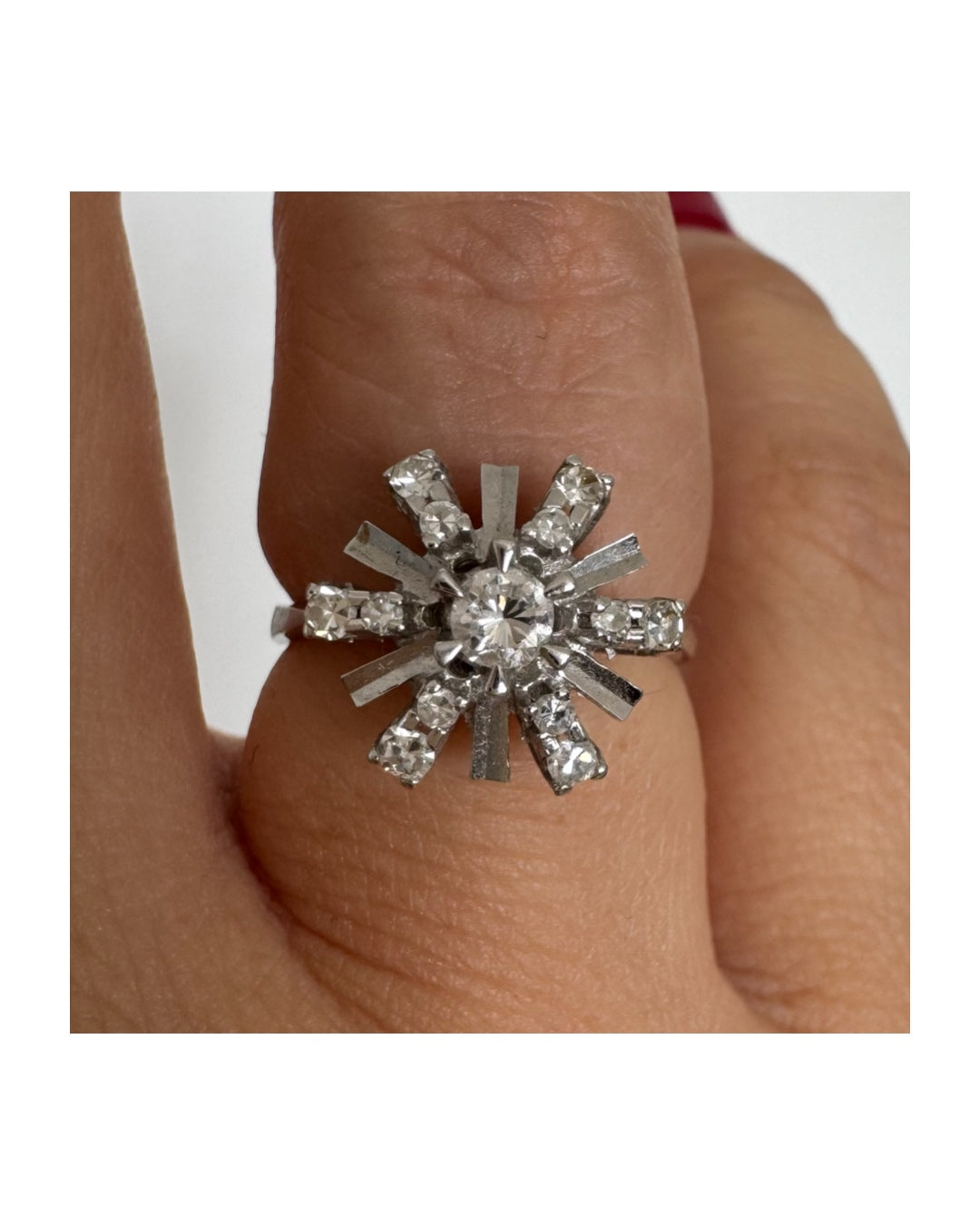 טבעת זהב לבן 18 קראט בעיצוב קרני שמש מרהיב, משובצת יהלומים הלוכדים את האור מכל כיוון. 