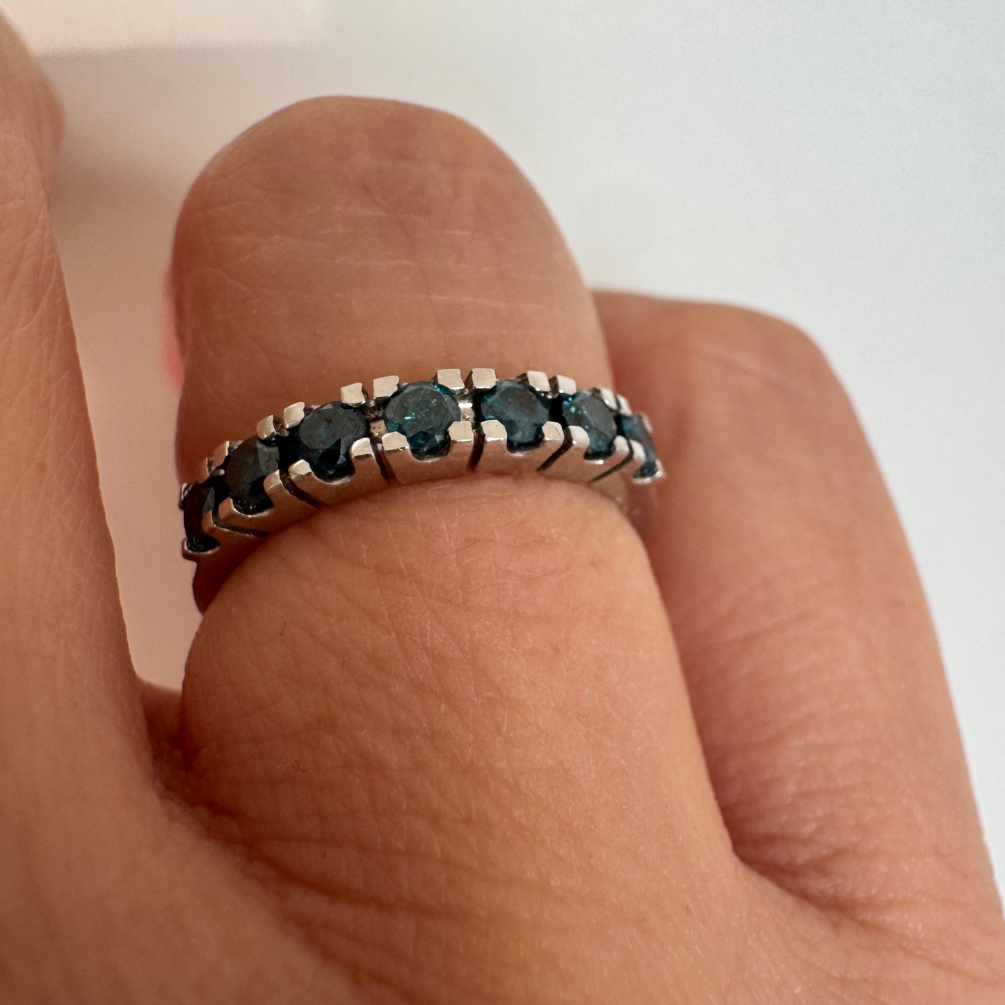 טבעת זהב לבן 14 קראט משובצת יהלומים כחולים בגוון עמוק וייחודי.