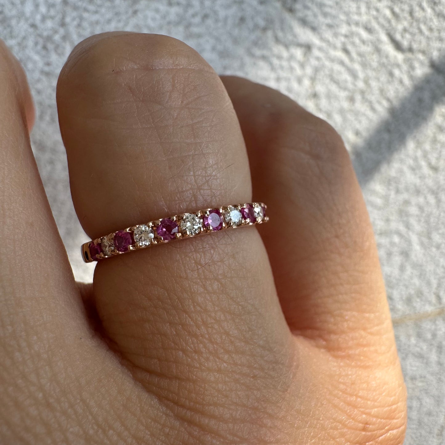 טבעת חצי איטרניטי מזהב אדום 14 קראט, משובצת ברצף של אבני רובי ויהלומים .