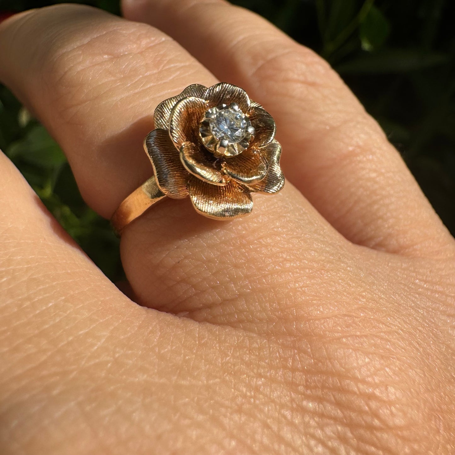 14K Gold floral ring set with delicately textured petals and a sparkling Diamond at the center