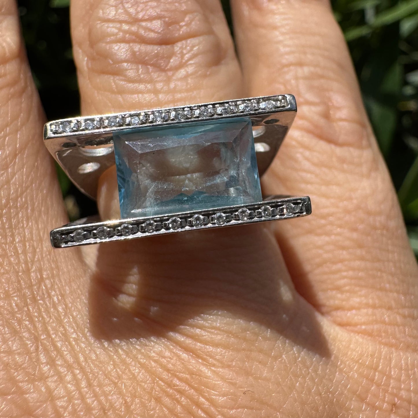 18K gold ring set with a stunning Aquamarine centerpiece held between two sleek gold bars set with delicate Diamonds.