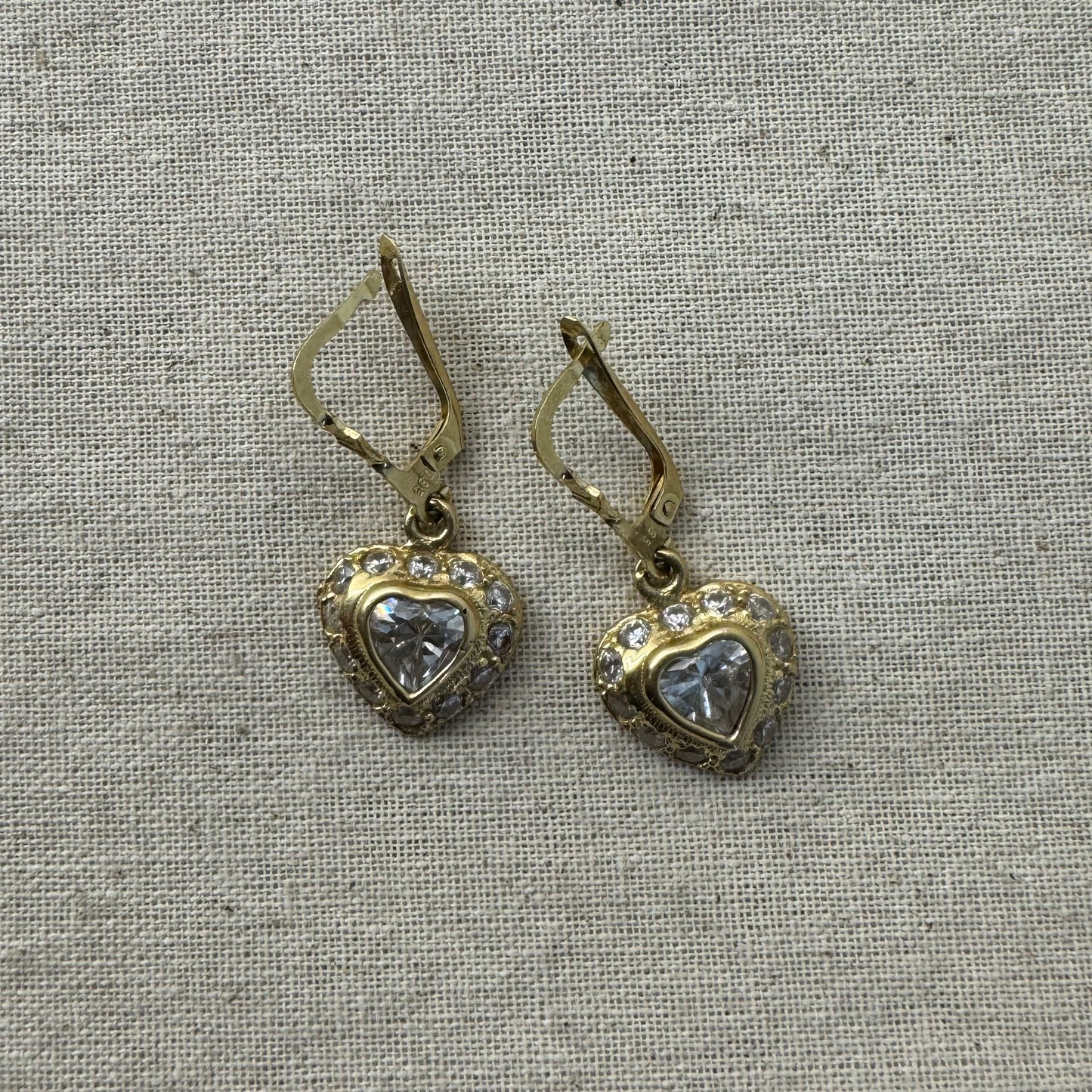 14K gold drop earrings set with a heart-cut central stone & surrounded by a halo of delicate gems.