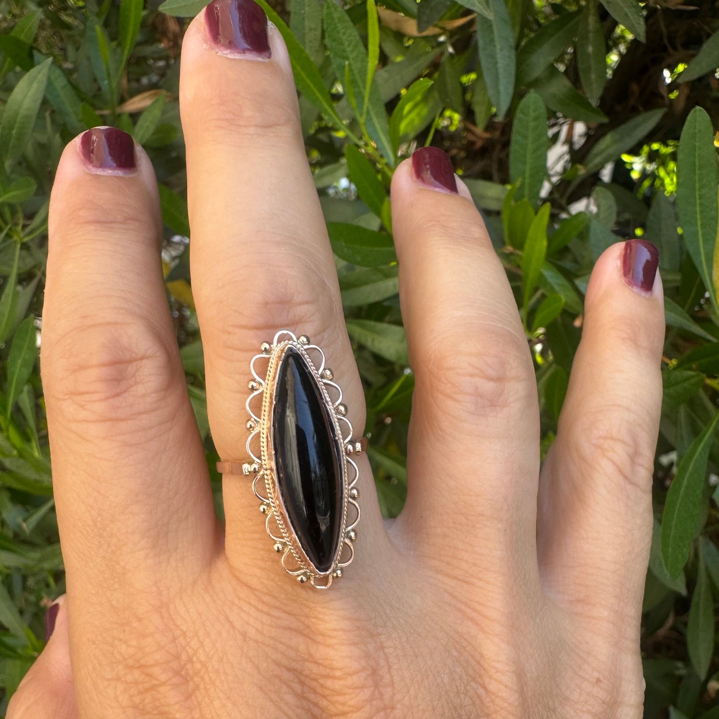 14K gold ring featuring a long marquise-shaped black Onyx stone, framed with delicate decorative details around the setting.
