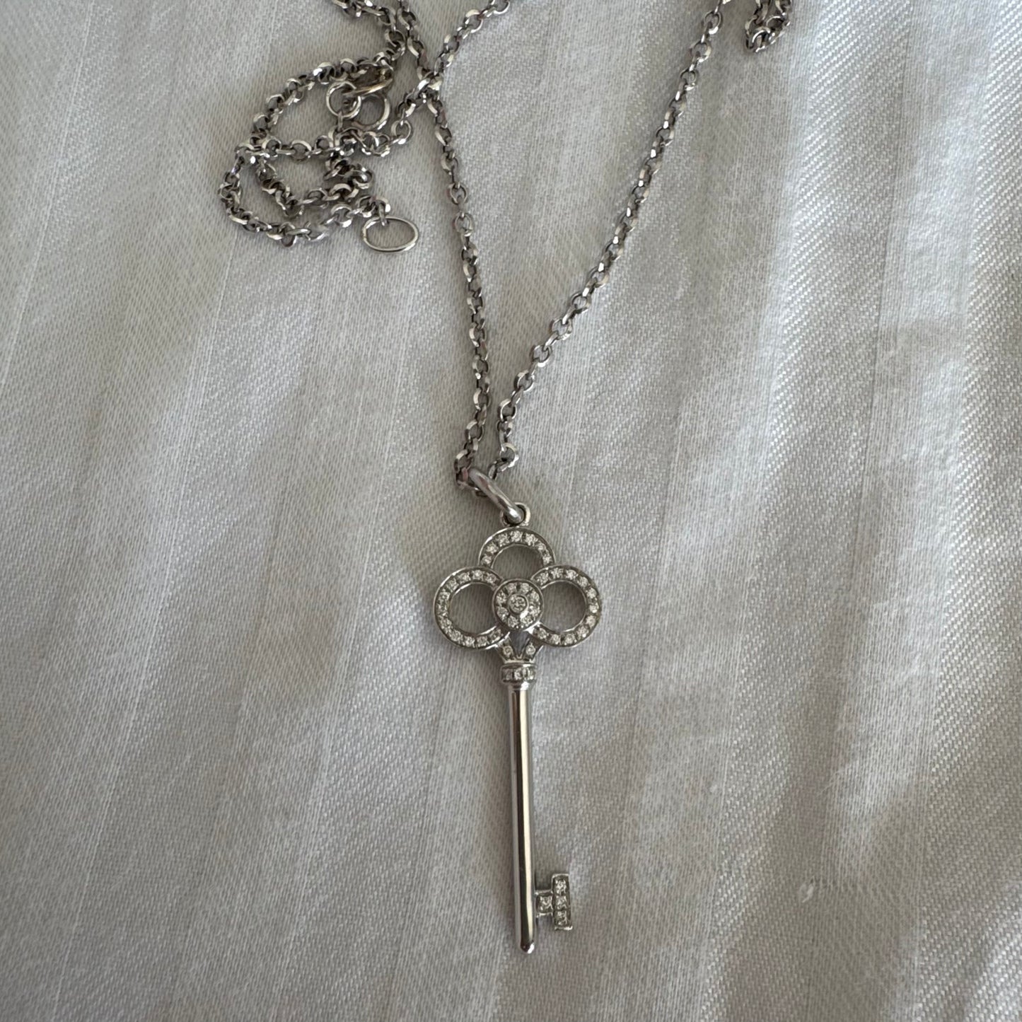 תליון מפתח אייקוני של Tiffany & Co. זהב לבן 18 קראט משובץ יהלומים עדינים.