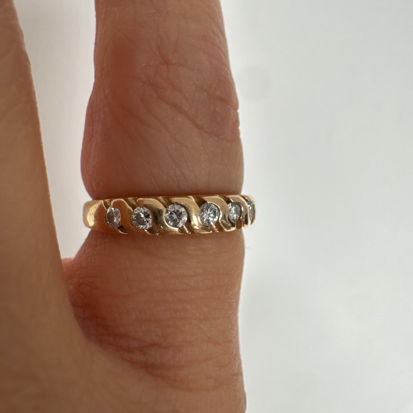 טבעת זהב צהוב 14 קראט משובצת יהלומים בחיתוך עגול, בשיבוץ מחורץ היוצר מראה ייחודי ומלא תנועה.