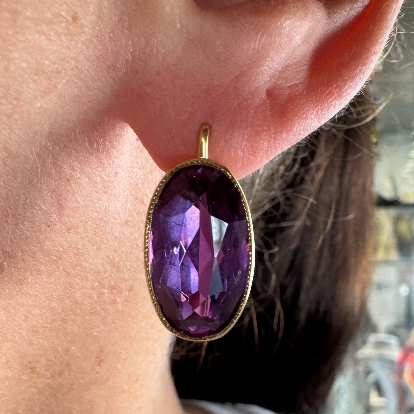 עגילי זהב צהוב 18 קראט, תלויים קצרים, משובצים באבני אמטיסט סגולות בחיתוך אובלי עמוק.