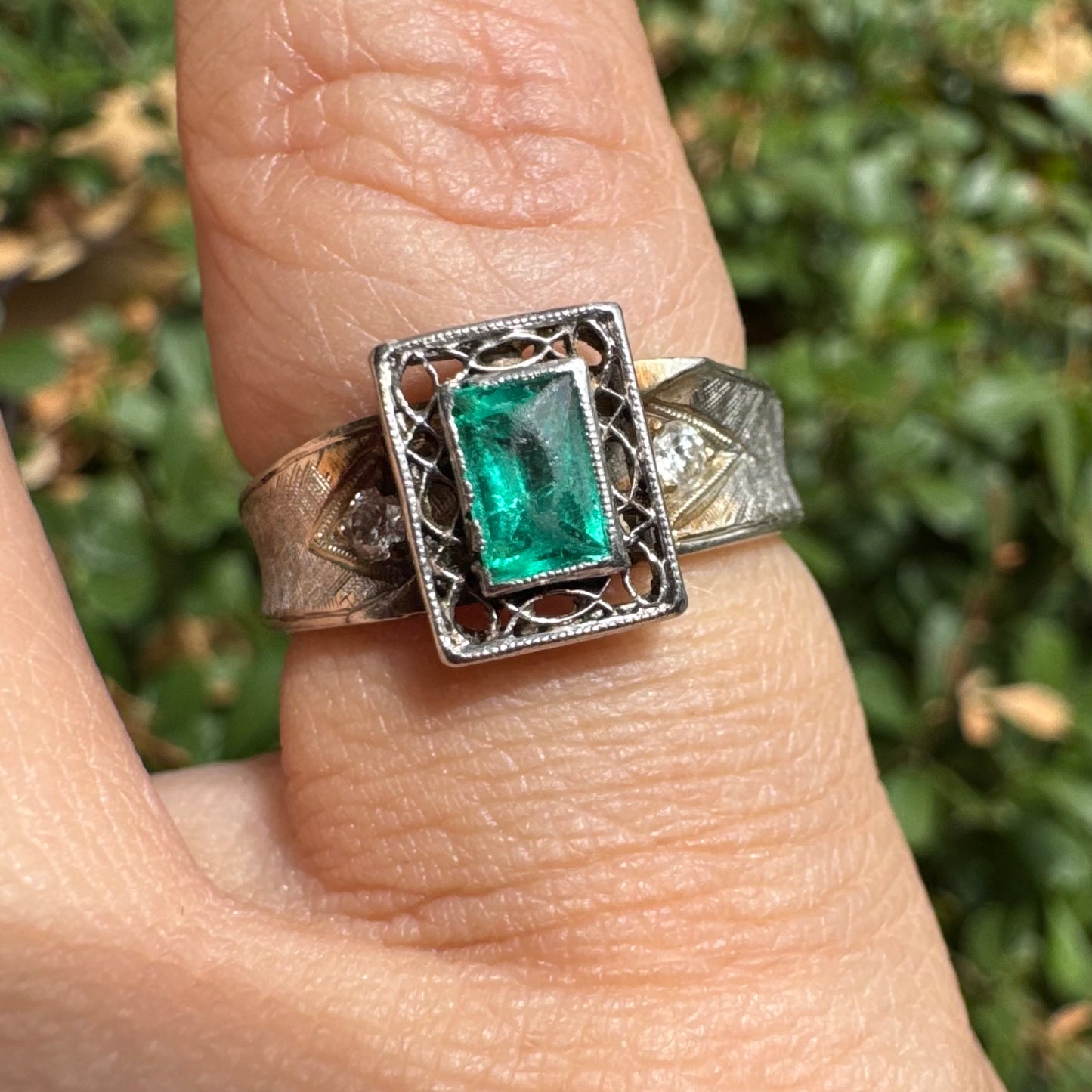14K gold ring set with a vibrant emerald-cut Emerald at its center, framed by delicate filigree work
