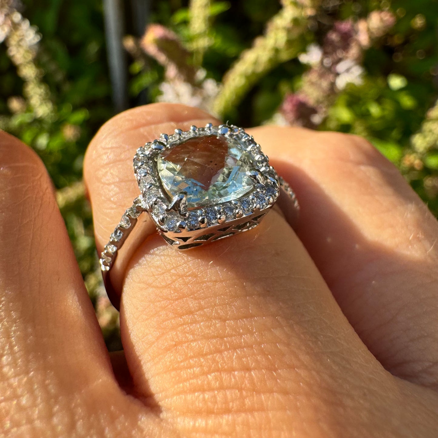 14K white gold ring featuring a cushion-cut light blue Aquamarine set in a sparkling double halo of round-cut Diamonds.