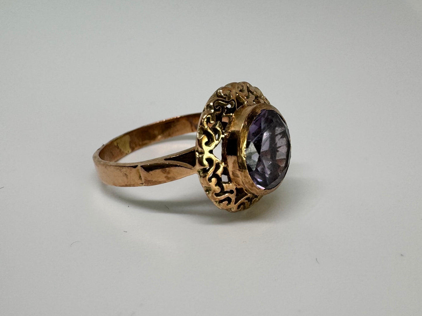 14K gold ring set with a large round-cut Tanzanite framed by an ornate filigree bezel