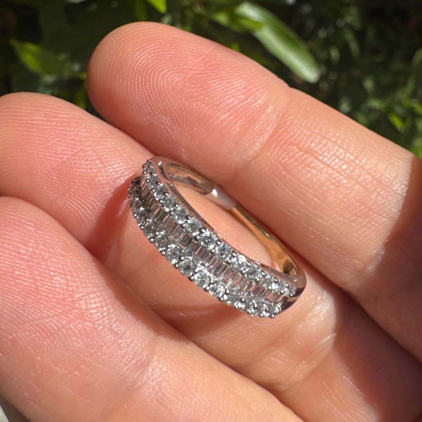 14K gold ring set with a row of baguette-cut diamonds framed by two rows of brilliant round diamonds