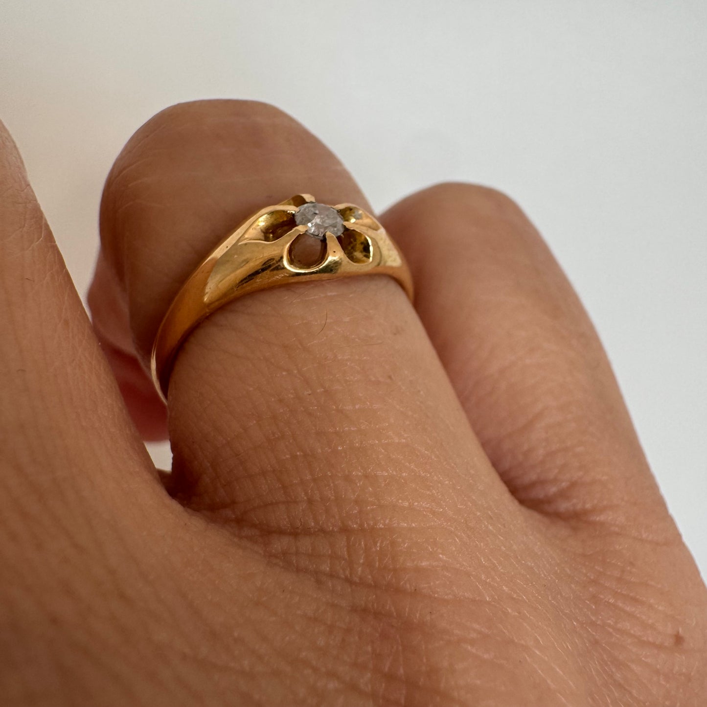 טבעת זהב צהוב 18 קראט בעיצוב פרח עדין, משובצת יהלום מרכזי בתוך עלי כותרת פתוחים.