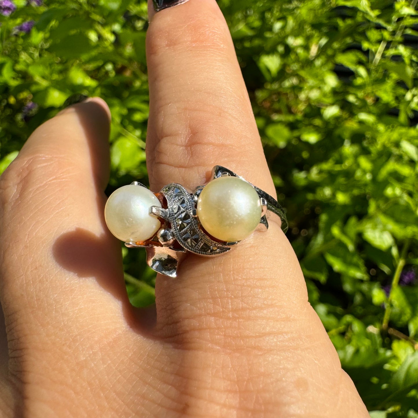 14K gold ring featuring two round white pearls set side by side, accented with a small decorative detail between them & Diamonds
