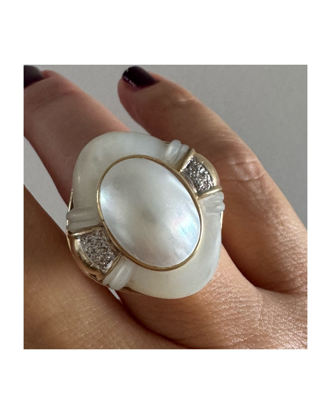 טבעת זהב צהוב 14 קראט משובצת באבן אם הפנינה טבעית במראה זוהר, עם שיבוץ יהלומים עדין בצדדים.