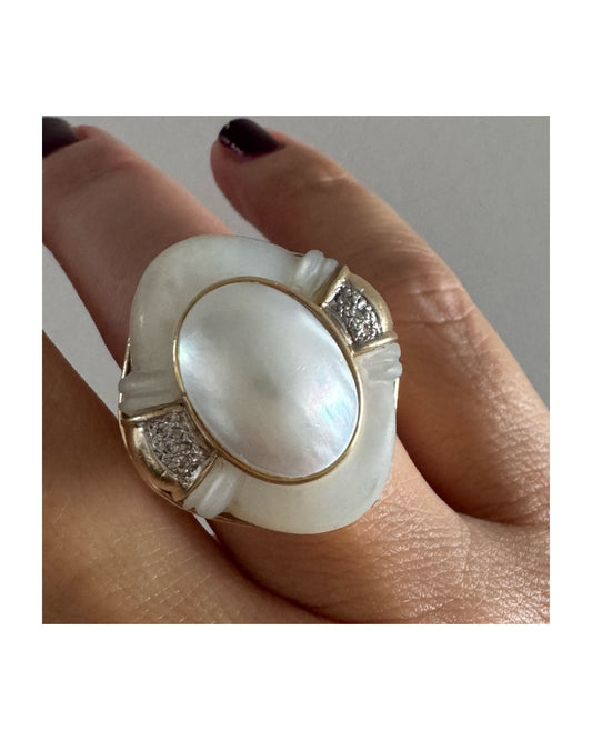 טבעת זהב צהוב 14 קראט משובצת באבן אם הפנינה טבעית במראה זוהר, עם שיבוץ יהלומים עדין בצדדים.